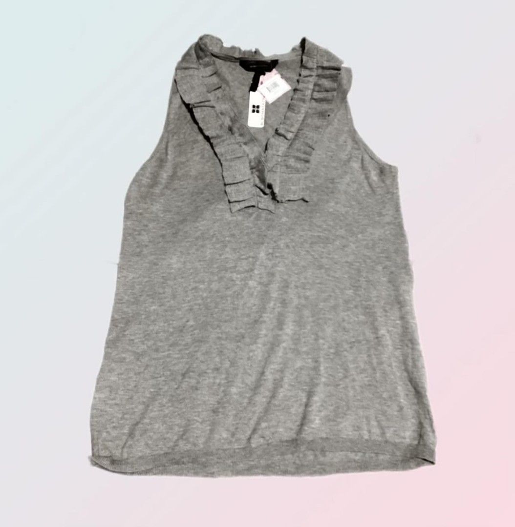 BCBGMAXAZRIA Gray Ruffled Sleeveless Tank Top (Category: Sleeveless) located in Paranaque City. Submitted by calm_youngstore7 (Listing ID 1469041705, Image 3). Description: - Brand: BCBGMAXAZRIA - Color: Elegant gray - Design: Sleeveless with a chic ruffled neckline - Material: Soft, comfortable knit fabric - Condition: Brand new with original tags attached (Never worn) - Style: Versatile for casual outings or smart-casual looks.