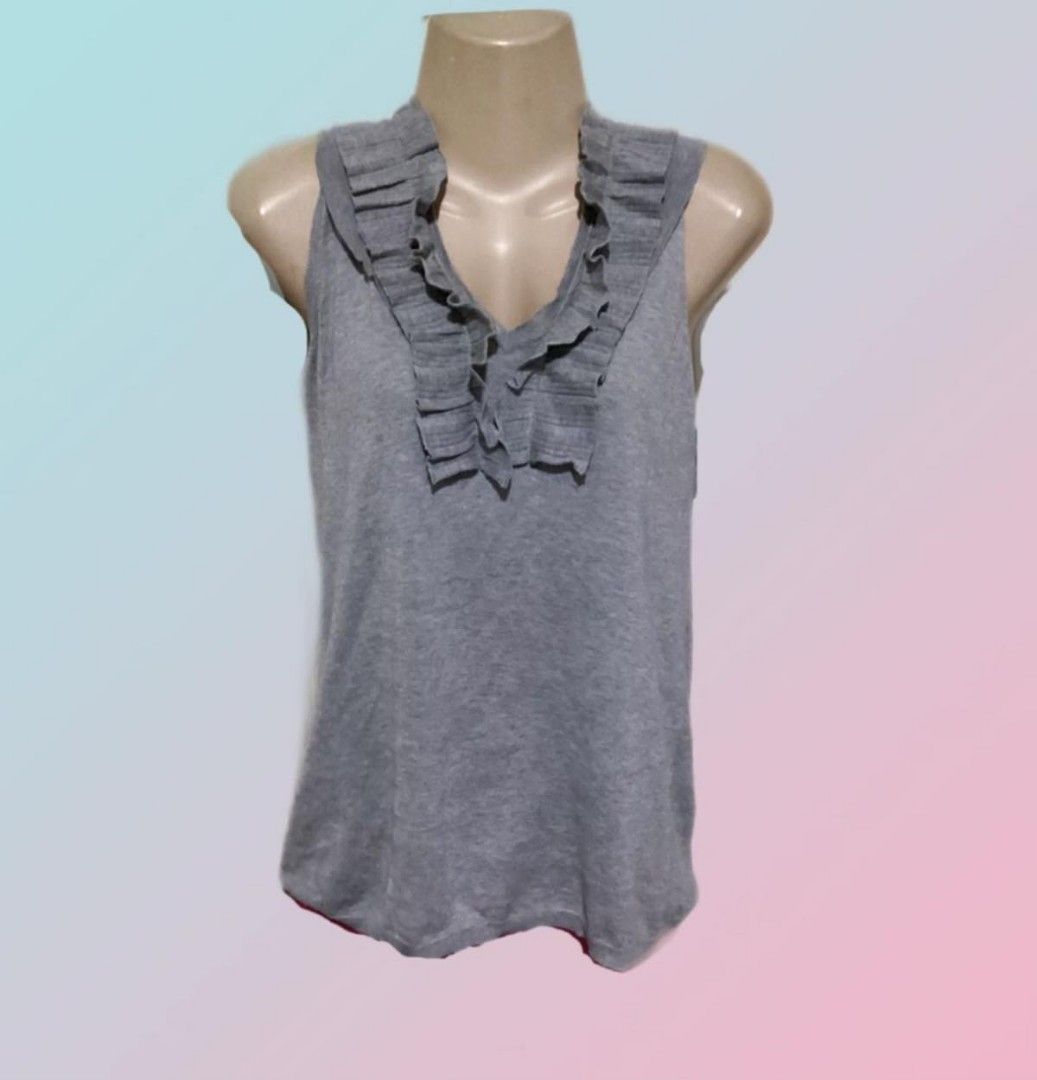 BCBGMAXAZRIA Gray Ruffled Sleeveless Tank Top (Category: Sleeveless) located in Paranaque City. Submitted by calm_youngstore7 (Listing ID 1469041705, Image 1). Description: - Brand: BCBGMAXAZRIA - Color: Elegant gray - Design: Sleeveless with a chic ruffled neckline - Material: Soft, comfortable knit fabric - Condition: Brand new with original tags attached (Never worn) - Style: Versatile for casual outings or smart-casual looks.