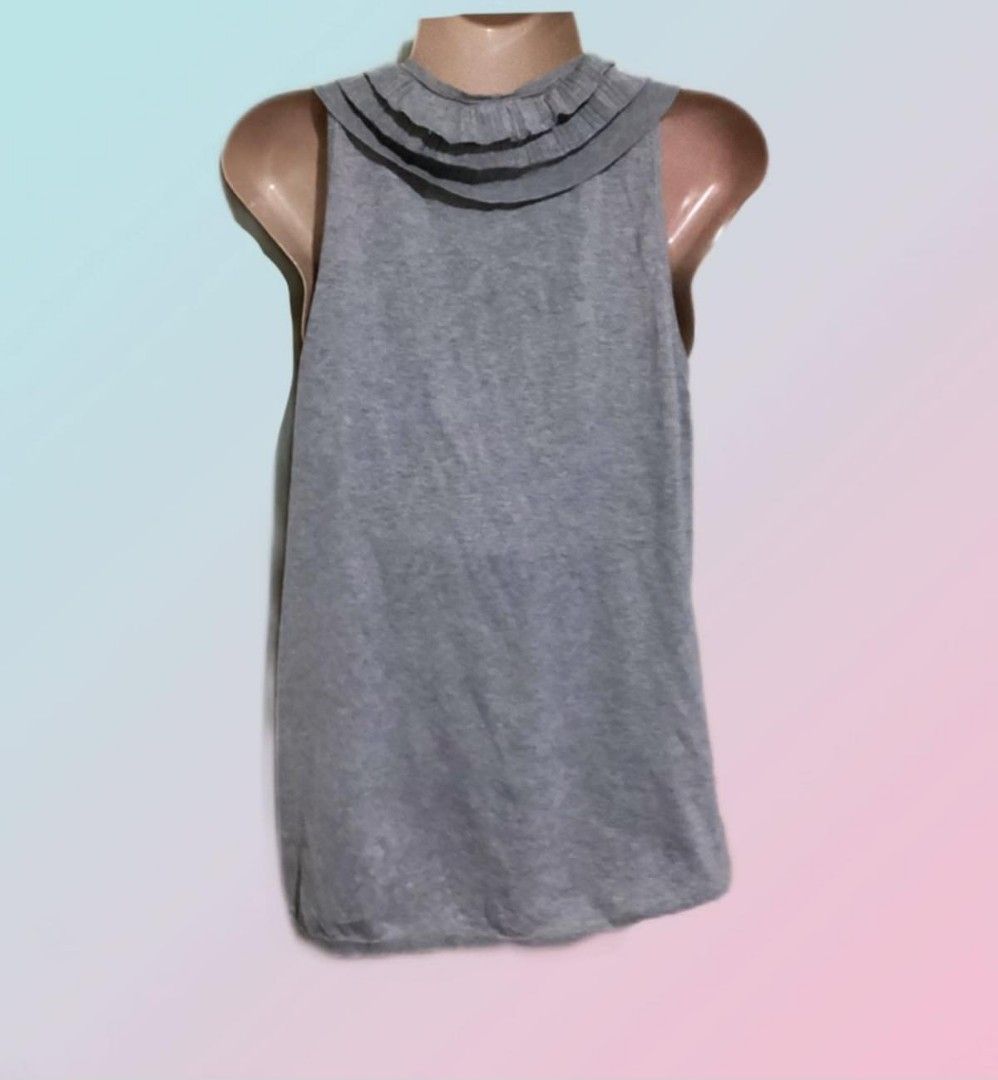 BCBGMAXAZRIA Gray Ruffled Sleeveless Tank Top (Category: Sleeveless) located in Paranaque City. Submitted by calm_youngstore7 (Listing ID 1469041705, Image 2). Description: - Brand: BCBGMAXAZRIA - Color: Elegant gray - Design: Sleeveless with a chic ruffled neckline - Material: Soft, comfortable knit fabric - Condition: Brand new with original tags attached (Never worn) - Style: Versatile for casual outings or smart-casual looks.