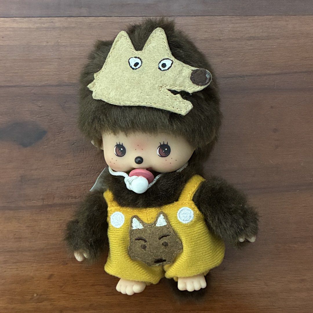 Bebichhichi Monchhichi Wolf Costume Plush Doll (Category: Plushies & Soft Toys) located in Manila. Submitted by pouijbol (Listing ID 1469097911, Image 1). Description: - Authentic Monchhichi plush doll in pristine condition - Dressed in cute yellow overalls with a fun wolf face pocket - Comes with a matching wolf hood accessory - Iconic thumb-sucking pose with a pacifier attached around the neck - Original branding tag and care instructions attac