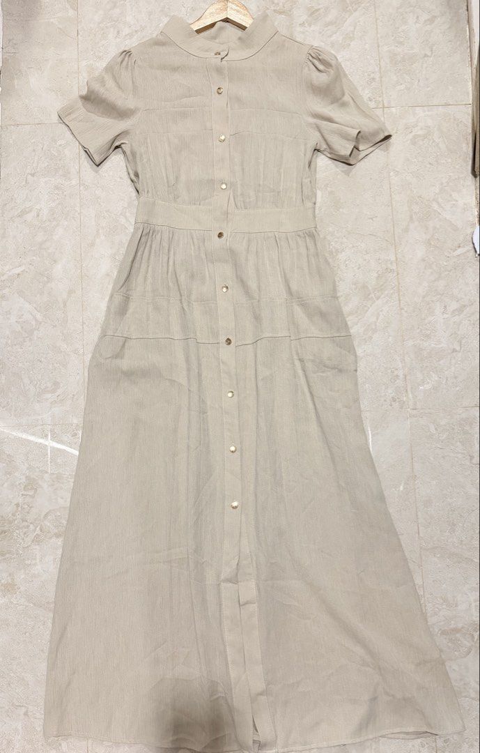 Beige Button-Front Dress Size S (Category: Dresses) located in Quezon City. Submitted by welovedclothing (Listing ID 1469002142, Image 2). Description: - Color: Beige - Size: S (tag attached at inner collar) - Style: Short sleeve midi dress with mandarin collar and gold-tone front buttons - Details: Fitted waist with a gathered skirt and all-over textured fabric - Versatility: Perfect for both casual outings and workwear.