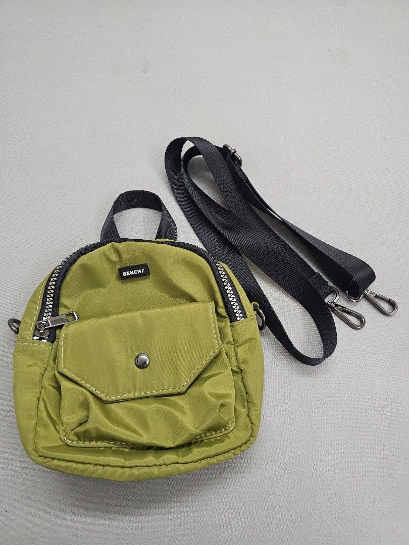 Bench Olive Green Mini Crossbody Bag (Category: Cross-body Bags) located in Marikina City. Submitted by czarinahwithh (Listing ID 1469060687, Image 1). Description: - Brand: Bench - Color: Olive green - Material: Lightweight nylon fabric with beige cloth interior - Compartments: Zippered main compartment and front pocket with snap button closure - Strap: Adjustable black strap with tone metal clasps.