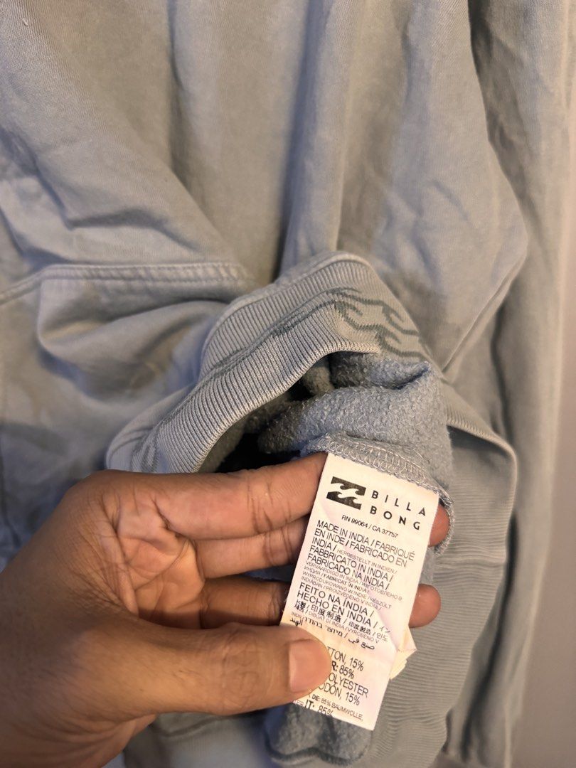 Billabong Grey Pullover Hoodie Size L (Category: Hoodies) located in Alaminos. Submitted by outfitcheck.ph (Listing ID 1469103343, Image 3). Description: - Brand: Billabong - Size: L (Regular fit) - Color: Grey - Material: Cotton and polyester blend (Made in India) - Interior: Soft fleece lining - Features: Adjustable drawstring hood, kangaroo front pocket - Details: Small embroidered chest script and subtle wave graphic hem - Condition: Great fo