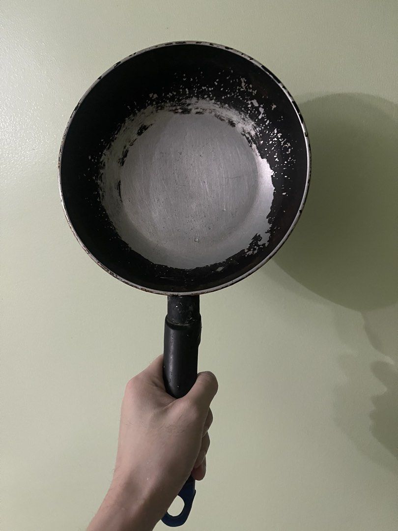 Black and silver frying pan with handle (Category: Cookware & Accessories) located in Manila. Submitted by pasaybestfinds (Listing ID 1469070220, Image 1). Description: - Used frying pan, still functional for everyday cooking - Non-stick coating on the inside base is heavily worn, exposing bare metal - Bottom is heavily scorched with black burnt residue - Equipped with a black handle featuring a convenient hanging hole - Ideal for buyers who don'
