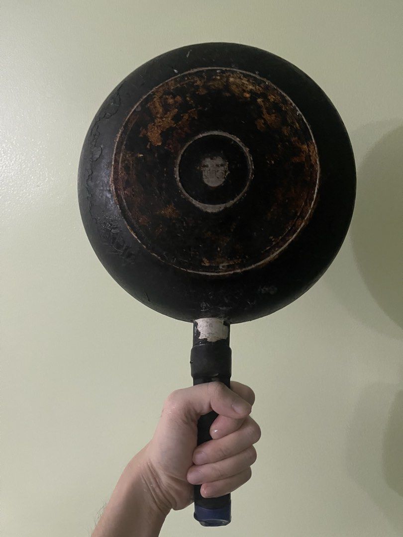 Black and silver frying pan with handle (Category: Cookware & Accessories) located in Manila. Submitted by pasaybestfinds (Listing ID 1469070220, Image 2). Description: - Used frying pan, still functional for everyday cooking - Non-stick coating on the inside base is heavily worn, exposing bare metal - Bottom is heavily scorched with black burnt residue - Equipped with a black handle featuring a convenient hanging hole - Ideal for buyers who don'