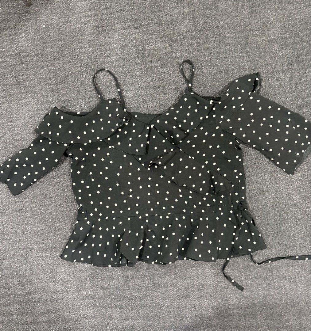 Black and White Polka Dot Off-Shoulder Ruffle Blouse (Category: Blouses) located in Quezon City. Submitted by fast.closetfinds (Listing ID 1469014749, Image 1). Description: - Design: Black and white polka dot with cold-shoulder cutouts - Details: Ruffle neckline, front wrap style, and side tie string - Straps: Thin spaghetti straps - Fit: Flowy peplum hemline made from lightweight fabric - Condition: Worn a few times, still in great shape - Perf