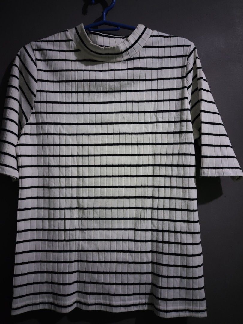 Black and white striped ribbed mock neck top (Category: Shirts) located in Manila. Submitted by rarelion_c637f7 (Listing ID 1469016301, Image 1). Description: - Design: Timeless black and white horizontal stripes - Material: Stretchy, comfortable ribbed knit - Neckline & Sleeves: Chic mock neck with half sleeves - Quality: Clean, durable stitching on hem and cuffs - Versatility: Essential basic piece for layering or wearing solo - Condition: Good