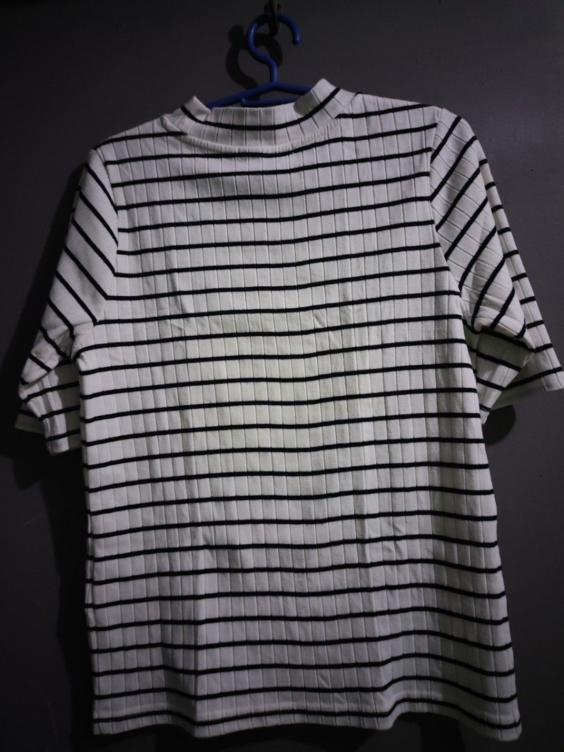 Black and white striped ribbed mock neck top (Category: Shirts) located in Manila. Submitted by rarelion_c637f7 (Listing ID 1469016301, Image 2). Description: - Design: Timeless black and white horizontal stripes - Material: Stretchy, comfortable ribbed knit - Neckline & Sleeves: Chic mock neck with half sleeves - Quality: Clean, durable stitching on hem and cuffs - Versatility: Essential basic piece for layering or wearing solo - Condition: Good