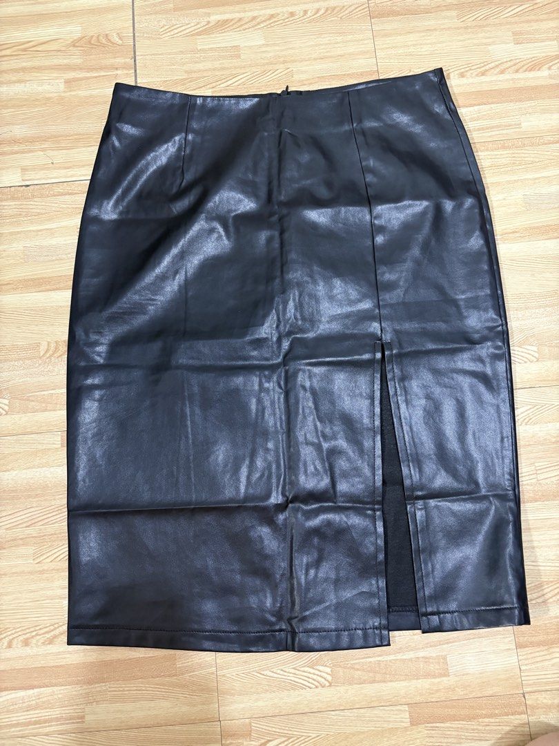 Black Faux Leather Midi Skirt with Side Split (Category: Skirts) located in Cainta. Submitted by tokadore (Listing ID 1468966270, Image 3). Description: - Color: Classic black - Material: Smooth faux leather - Style: High waist midi skirt with back zipper - Detail: Front side slit for easy movement - Condition: Good, but has a small tear at the top corner of the slit seam that needs a quick stitch L- 25 W -30.