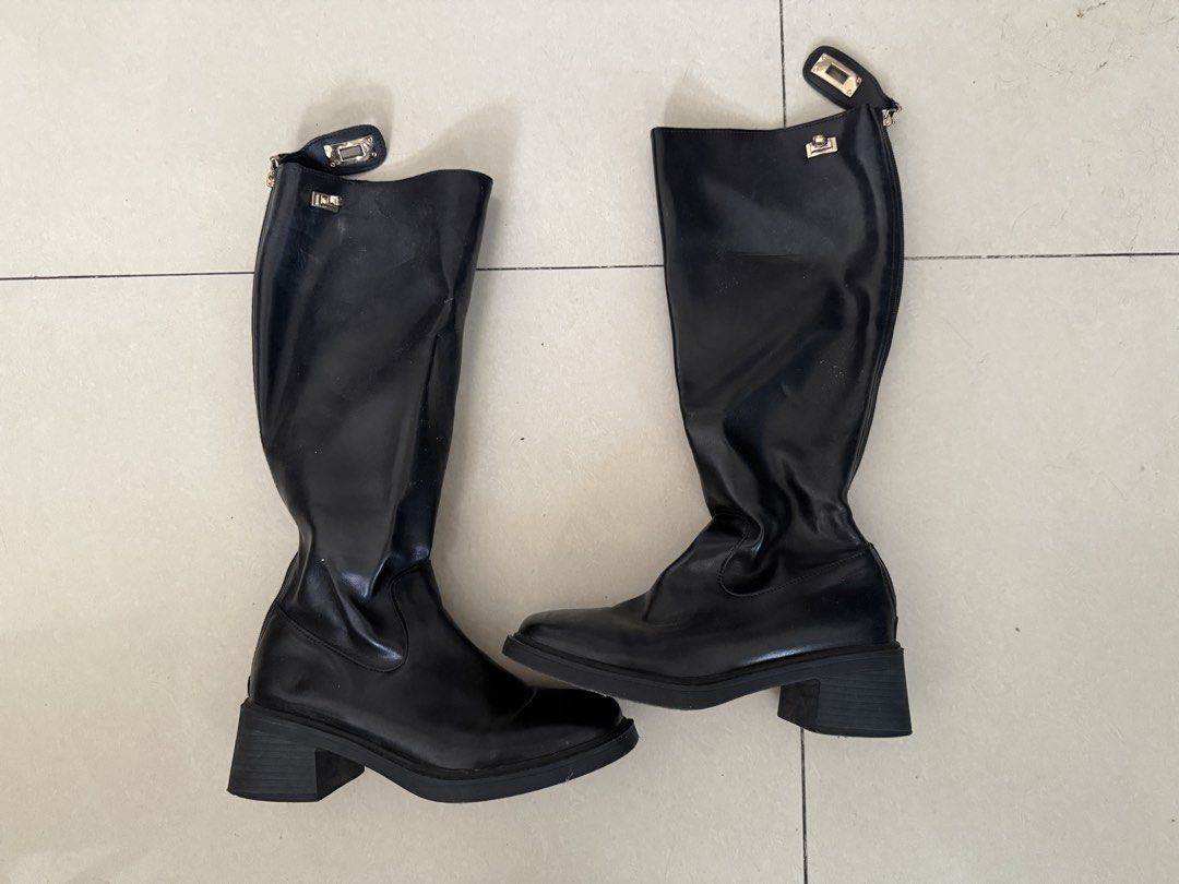 Black High Boots with Gold Lock Detail (Category: Boots) located in Manila. Submitted by arianneliz18 (Listing ID 1468956659, Image 2). Description: - Style: Knee-high boots with chunky block heels and rounded square toes - Material: Smooth black faux leather - Details: Chic gold metallic hardware lock closure near the top - Convenience: Side zipper design for easy wear - Condition: Clean soles with minimal signs of wear - Season: Great for autum