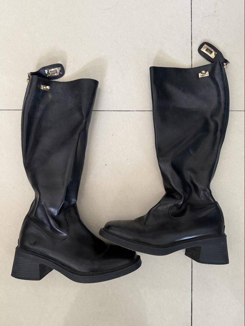 Black High Boots with Gold Lock Detail (Category: Boots) located in Manila. Submitted by arianneliz18 (Listing ID 1468956659, Image 1). Description: - Style: Knee-high boots with chunky block heels and rounded square toes - Material: Smooth black faux leather - Details: Chic gold metallic hardware lock closure near the top - Convenience: Side zipper design for easy wear - Condition: Clean soles with minimal signs of wear - Season: Great for autum