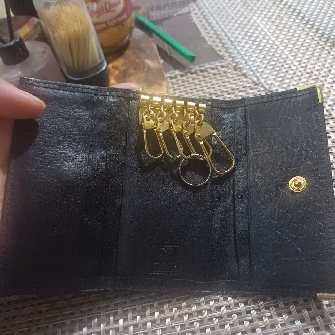Black leather key case holder (Category: Wallets & Card holders) located in Manila. Submitted by borbone13335092 (Listing ID 1468930803, Image 3). Description: - Color/Material: Black leather with elegant gold-toned hardware - Closure: Secure front flap with snap button - Interior: Multiple key hooks plus a convenient split ring - Size: Compact and pocket-friendly - Condition: Clean inside and out, ready for daily use.