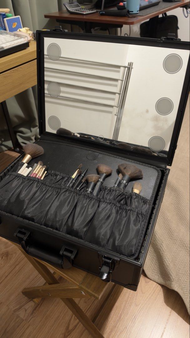 Black makeup vanity case/box with lighted mirror (Category: Makeup) located in Taguig. Submitted by honsells (Listing ID 1468964510, Image 1). Description: - Sleek black aluminum vanity case with built-in lighted mirror - Customizable interior with adjustable dividers for easy organization - Includes various makeup brushes, lipsticks, lip glosses, and cosmetics as shown - Comes with a matching cream-colored pouch - Features a sturdy top handle an