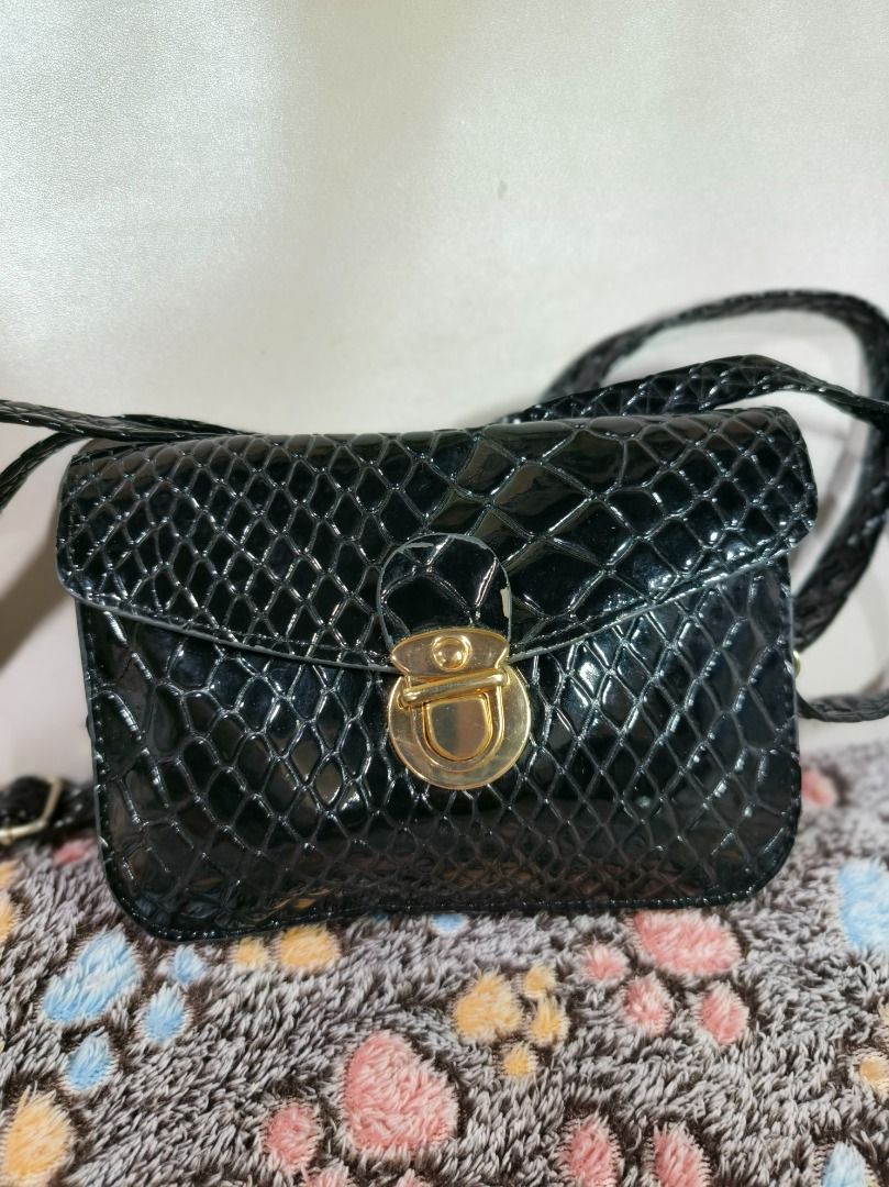 Black Snake Pattern Crossbody Bag with Gold Lock (Category: Cross-body Bags) located in San Leonardo. Submitted by burgossanleonardo.12345 (Listing ID 1469067752, Image 2). Description: - Color & Material: Black faux leather with a glossy finish - Design: Embossed snake pattern with gold-toned twist lock closure - Dimensions: Approx. 14 cm (W) x 12 cm (H) - Strap: Includes matching black strap - Mode of Payment: GCash, BPI, or Bank Transfer - Shi