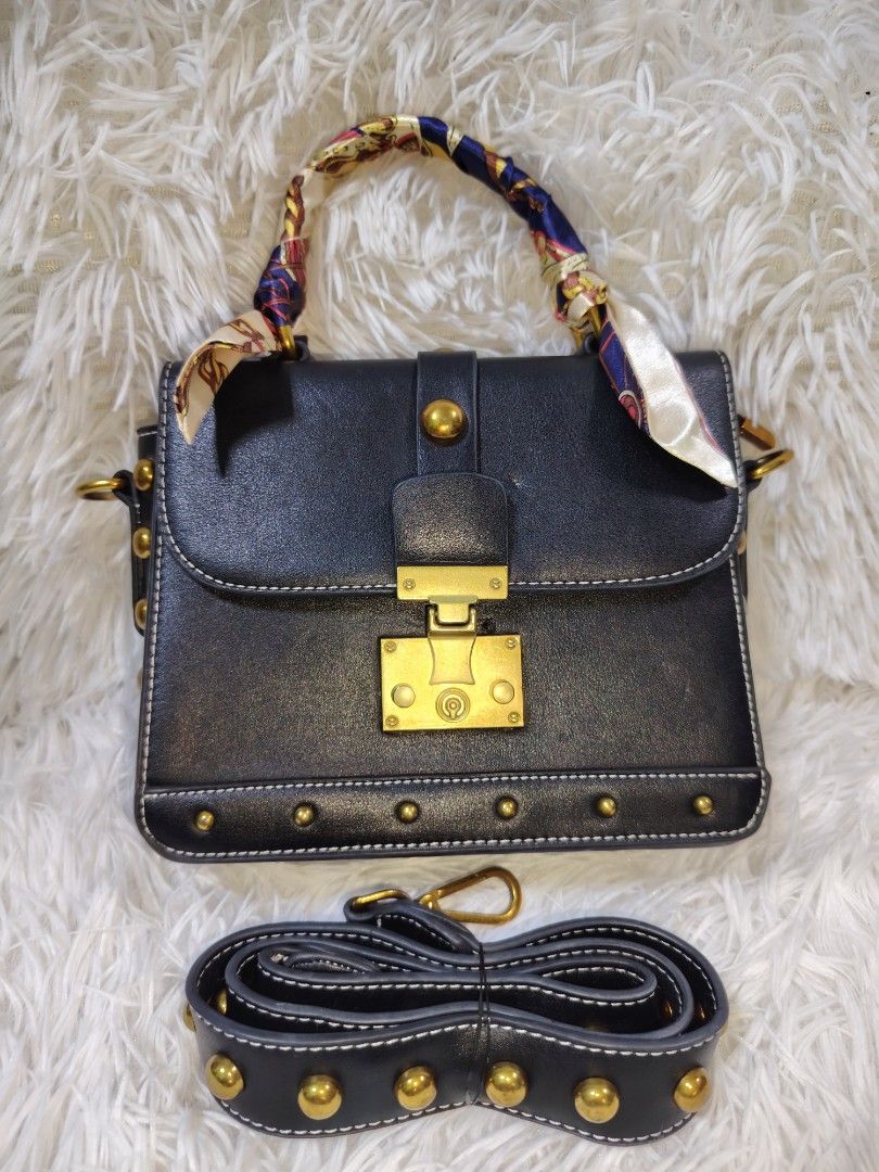 Black Structured Bag with Scarf Wrapped Handle and Studs (Category: Cross-body Bags) located in Quezon City. Submitted by zhelcloset01 (Listing ID 1469064177, Image 1). Description: - Style: Structured black handbag with gold-tone hardware - Details: Chic stud accents along the bottom edge and matching adjustable strap - Handle: Unique top handle wrapped in a colourful patterned scarf - Closure: Secure front flap with turn-lock closure - Interior