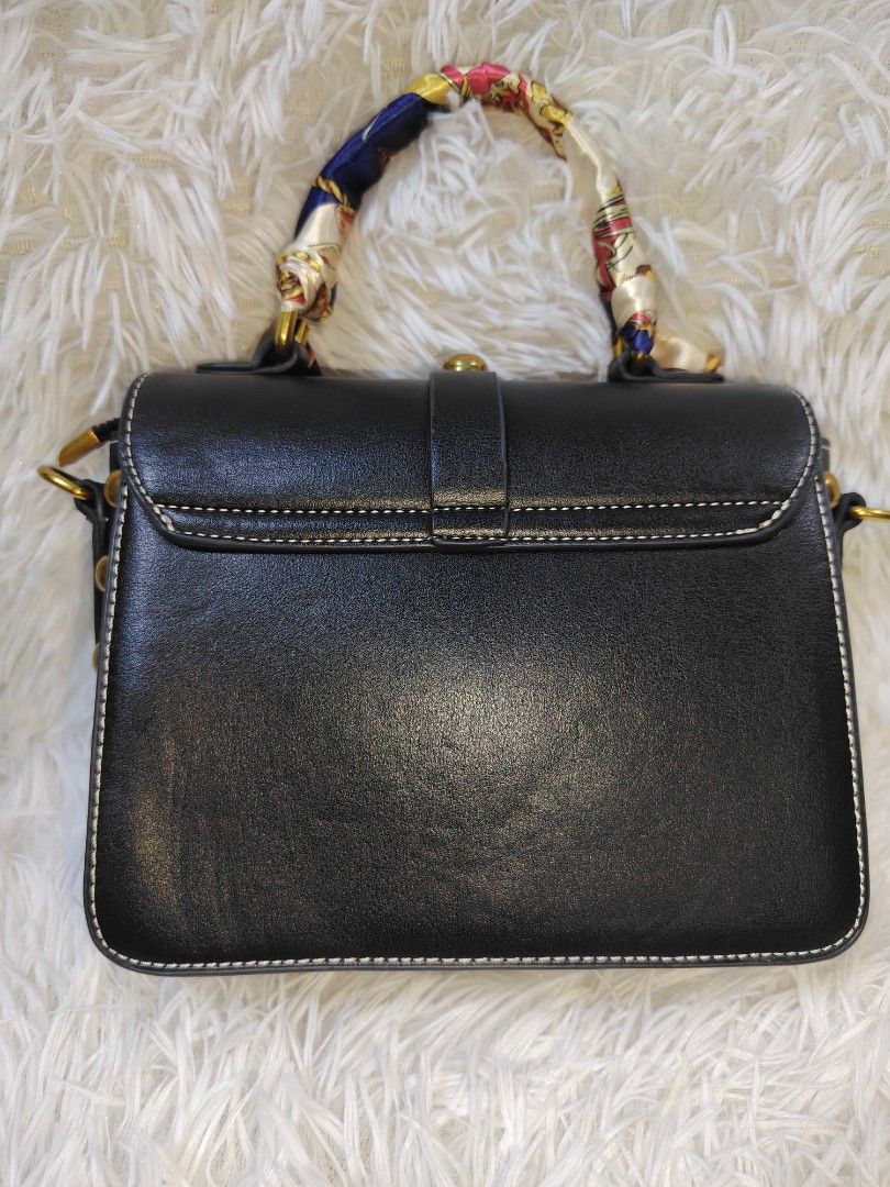 Black Structured Bag with Scarf Wrapped Handle and Studs (Category: Cross-body Bags) located in Quezon City. Submitted by zhelcloset01 (Listing ID 1469064177, Image 2). Description: - Style: Structured black handbag with gold-tone hardware - Details: Chic stud accents along the bottom edge and matching adjustable strap - Handle: Unique top handle wrapped in a colourful patterned scarf - Closure: Secure front flap with turn-lock closure - Interior