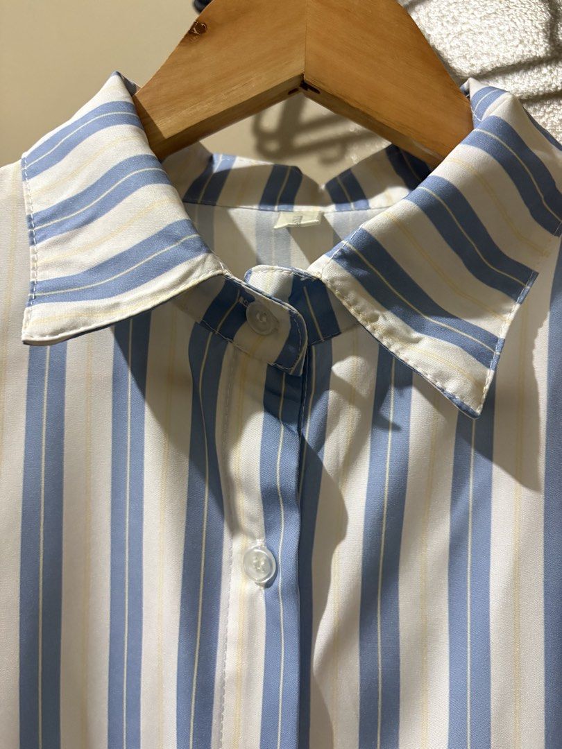 Blue and White Striped Button-Down Shirt (Category: Shirts) located in Caloocan City. Submitted by stella_mari27 (Listing ID 1469100417, Image 3). Description: - Color/Pattern: Blue and white vertical stripes - Design: Long sleeves, front button closure, and classic collar - Fit: Relaxed and comfortable - Material: Lightweight fabric - Styling: Easy to pair with jeans or trousers for casual wear.