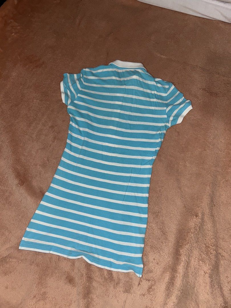 Blue and White Striped Polo Shirt (Category: Others Tops) located in Manila. Submitted by prelovedbyanavi (Listing ID 1468954727, Image 2). Description: - Design: Blue and white striped slim-fit polo - Features: Short sleeves, classic collar neckline, front button placket - Material: Soft and comfortable fabric with bright colors - Style: Great casual piece for everyday wear.