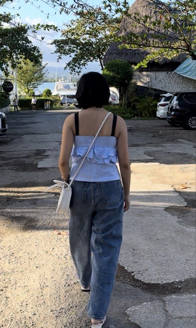 Blue and white striped ruffle camisole top (Category: Sleeveless) located in Cebu City. Submitted by swift.allyn (Listing ID 1469012634, Image 3). Description: Blue and white pinstripe camisole. Sweetheart neckline with black straps. Layered ruffle detail across the front. Cropped fit, pairs easily with high-waisted denim jeans. Lightweight fabric for warm weather outings. Worn a couple of times, still in great shape..
