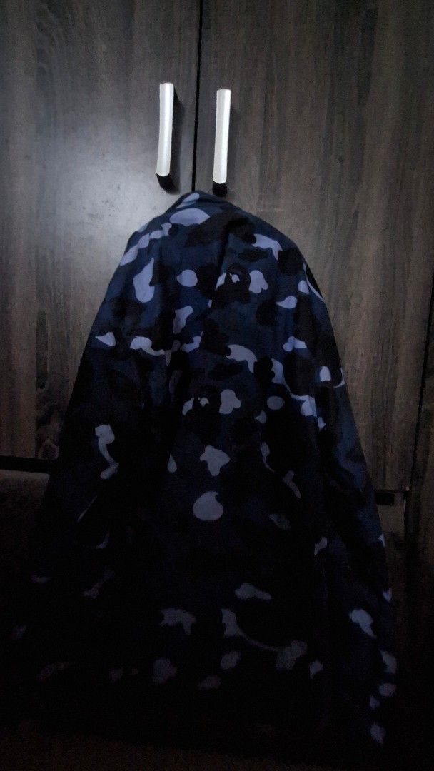 Blue camo kimono style jacket (Category: Coats, Jackets and Outerwear) located in Manila. Submitted by matter514 (Listing ID 1469117707, Image 2). Description: Colorway: Dark blue and black camouflage - Closure: Button-up front - Details: Iconic ape head logo patch on chest, clear inner brand tag - Style: Perfect layering piece for streetwear outfits.