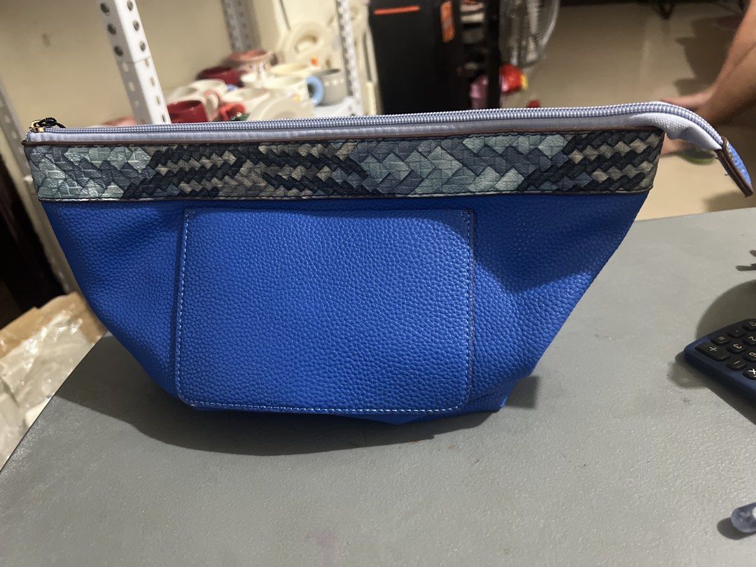Blue Makeup Pouch Cosmetic Bag with Pattern Trim (Category: Purses & Pouches) located in Manila. Submitted by ajdfinds (Listing ID 1469092498, Image 1). Description: - Color: Blue - Material: Faux leather with textured pebble finish - Design: Geometric pattern band near top zipper and front rectangular pocket patch - Interior: Light beige fabric lining with 1 zippered inner pocket and 1 slip pocket - Closure: Top zip closure.