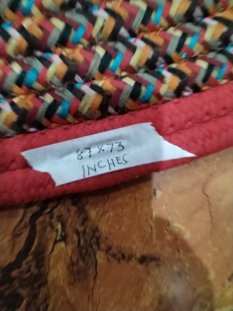 Braided Oval Rug Red Brown Multi 87x73 Inches (Category: Carpets, Mats & Flooring) located in Caloocan City. Submitted by rowely_jpn (Listing ID 1469100659, Image 3). Description: Japan surplus - Product: Oval braided rug with concentric rings - Size: 87 x 73 inches (based on handwritten label) - Color & Pattern: Red, brown, and multicoloured patterned weave - Material: Textured cotton/fabric construction - Durability: Heavy-duty floor covering -