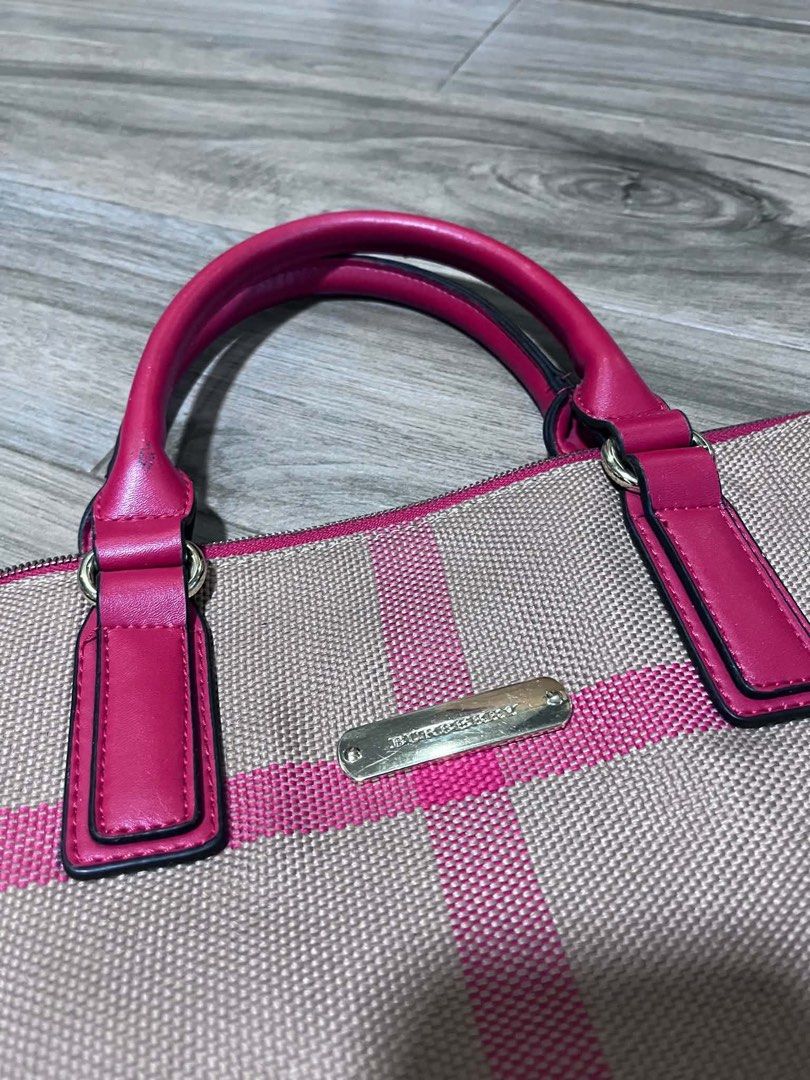 Burberry Plaid Handbag Pink (Category: Tote Bags) located in Dagupan City. Submitted by fahionista1988 (Listing ID 1469048722, Image 3). Description: - Brand: Burberry - Material: Pink plaid canvas with dark pink leather handles - Hardware: Gold-tone logo plaque and protective metal feet - Closure: Secure zip top - Interior: Plaid fabric lining, zip pocket, and embossed leather logo patch - Condition: Clean inside and out, well-maintained.