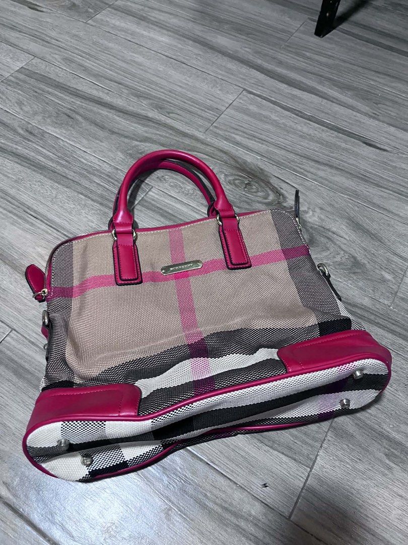 Burberry Plaid Handbag Pink (Category: Tote Bags) located in Dagupan City. Submitted by fahionista1988 (Listing ID 1469048722, Image 1). Description: - Brand: Burberry - Material: Pink plaid canvas with dark pink leather handles - Hardware: Gold-tone logo plaque and protective metal feet - Closure: Secure zip top - Interior: Plaid fabric lining, zip pocket, and embossed leather logo patch - Condition: Clean inside and out, well-maintained.