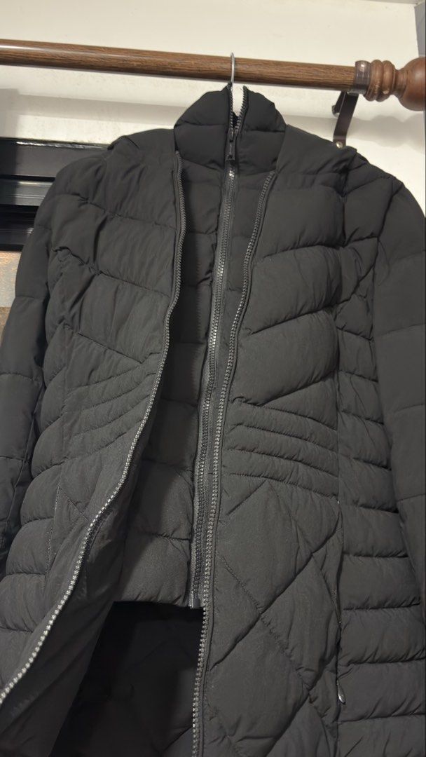 Calvin Klein Infinite Stretch Black Puffer Jacket (Category: Coats, Jackets and Outerwear) located in Manaoag. Submitted by rsnt31 (Listing ID 1469083182, Image 3). Description: - Brand: Calvin Klein (Infinite Stretch Line) - Color: Solid Black - Features: Hooded, zip-up front with branded pull, rubber logo patch on sleeve - Design: Quilted lower front with chevrons above - Condition: Clean fabric, smooth working zipper - Perfect for winter weath