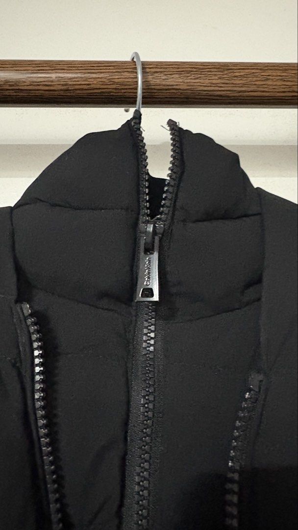 Calvin Klein Infinite Stretch Black Puffer Jacket (Category: Coats, Jackets and Outerwear) located in Manaoag. Submitted by rsnt31 (Listing ID 1469083182, Image 2). Description: - Brand: Calvin Klein (Infinite Stretch Line) - Color: Solid Black - Features: Hooded, zip-up front with branded pull, rubber logo patch on sleeve - Design: Quilted lower front with chevrons above - Condition: Clean fabric, smooth working zipper - Perfect for winter weath