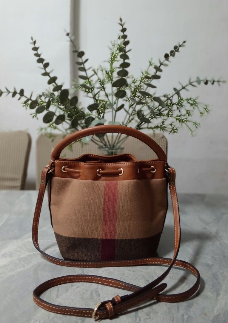 Canvas bucket bag with leather handle and strap (Category: Shoulder Bags) located in Manila. Submitted by cosmiccloud-9236 (Listing ID 1468964500, Image 2). Description: - Material: Durable canvas with stylish faux leather trim in brown and tan - Closure & Hardware: Secure top drawstring closure accented with gold-tone hardware rings - Straps: Includes a convenient short top handle and a long adjustable crossbody strap for versatile wear - Design