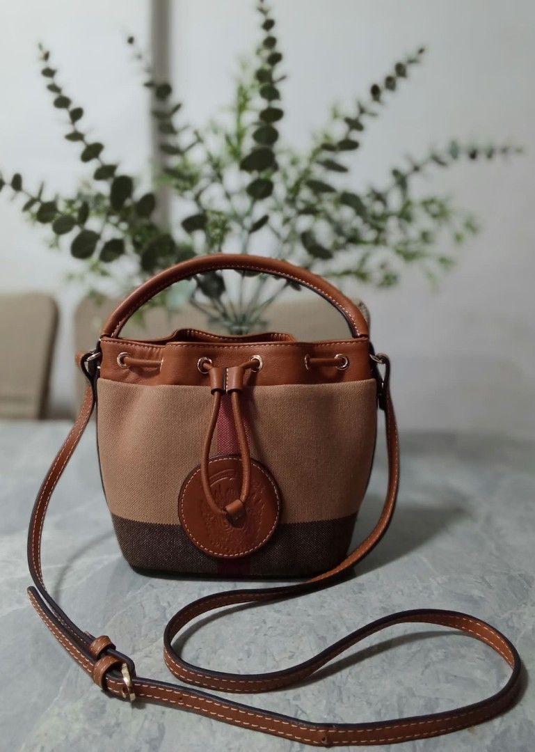 Canvas bucket bag with leather handle and strap (Category: Shoulder Bags) located in Manila. Submitted by cosmiccloud-9236 (Listing ID 1468964500, Image 1). Description: - Material: Durable canvas with stylish faux leather trim in brown and tan - Closure & Hardware: Secure top drawstring closure accented with gold-tone hardware rings - Straps: Includes a convenient short top handle and a long adjustable crossbody strap for versatile wear - Design