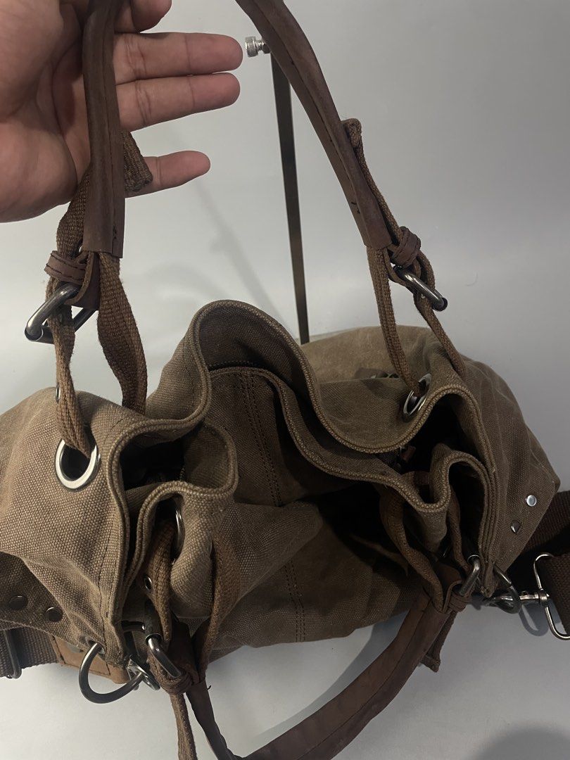 Canvas Shoulder Bag Brown Hobe Tote (Category: Shoulder Bags) located in Veruela. Submitted by blinkban_thrift (Listing ID 1469000967, Image 3). Description: - Style: Everyday slouchy carryall - Material: Brown canvas with dark brown fabric lining - Straps: Dual top handles and adjustable shoulder straps - Pockets: Front zipper pocket with leather pull tab, interior zipped compartment, and slip pockets - Closure: Secure zip top closure - Hardware
