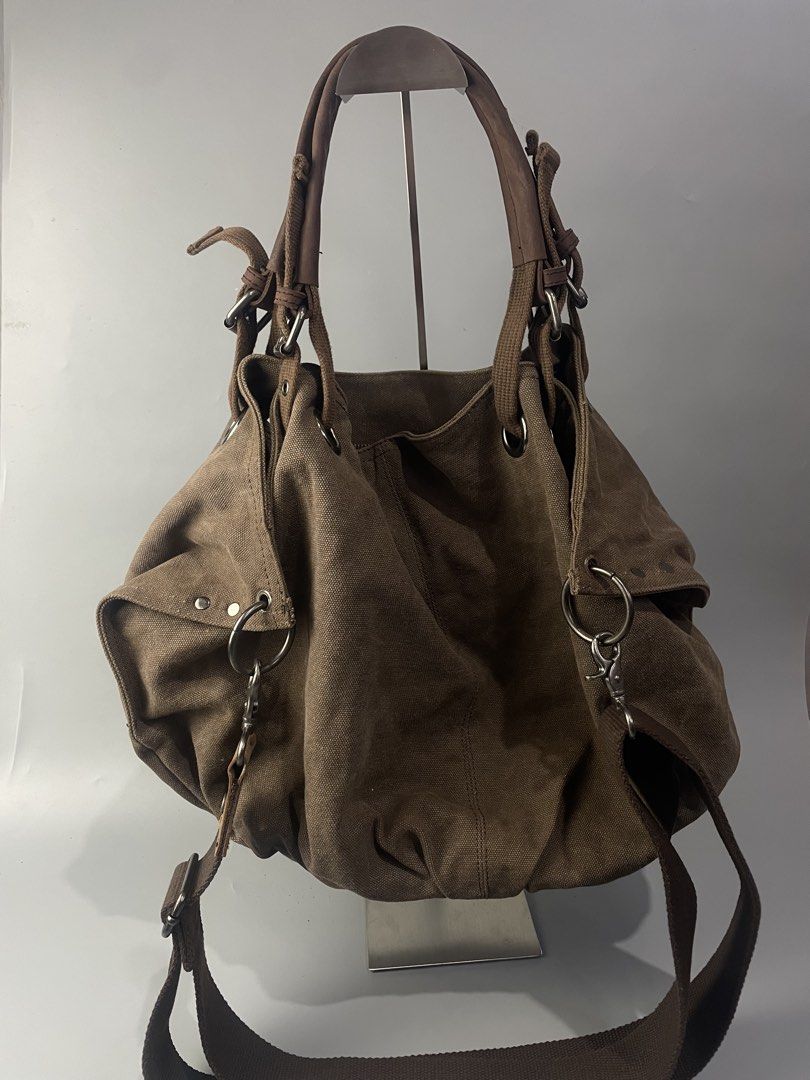 Canvas Shoulder Bag Brown Hobe Tote (Category: Shoulder Bags) located in Veruela. Submitted by blinkban_thrift (Listing ID 1469000967, Image 2). Description: - Style: Everyday slouchy carryall - Material: Brown canvas with dark brown fabric lining - Straps: Dual top handles and adjustable shoulder straps - Pockets: Front zipper pocket with leather pull tab, interior zipped compartment, and slip pockets - Closure: Secure zip top closure - Hardware