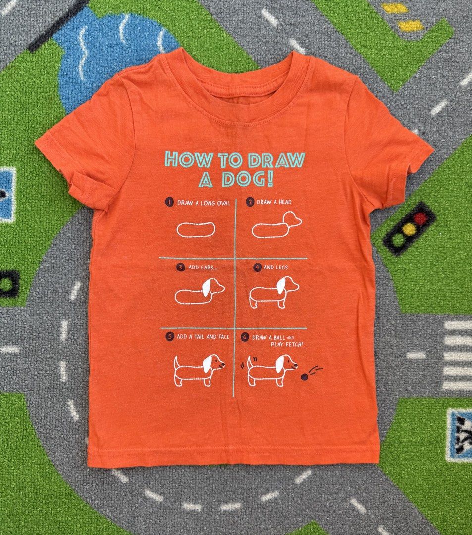 Cat & Jack Shirt (Category: Babies & Kids Fashion) located in Rizal. Submitted by preloovved (Listing ID 1468961843, Image 1). Description: Bright orange kids' tee featuring a cute step-by-step dachshund drawing guide. Made from soft, comfortable cotton with a classic crew neck. Perfect, fun everyday top for little ones! Preloved, 2yo Meet-up only in GB1 San Mateo, Rizal Shipping fee c/o buyer. Tres Marias or J&T express Payment to be sent to me 