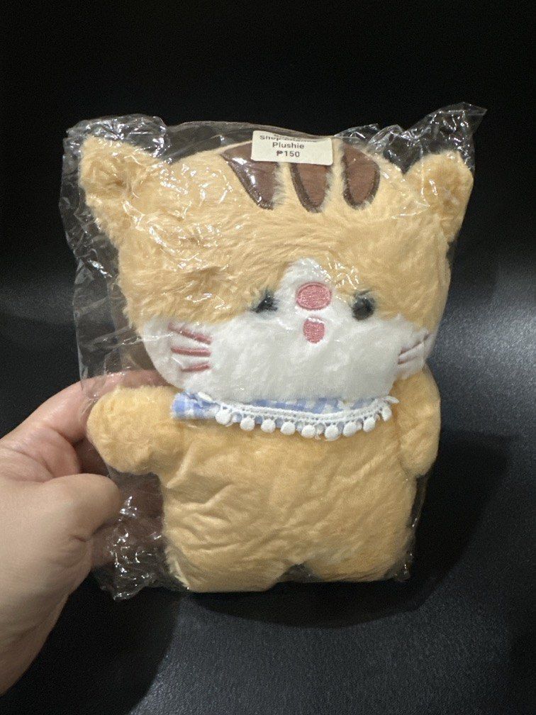 Cat stuffed toy (Category: Plushies & Soft Toys) located in Manila. Submitted by krystalchewey_ (Listing ID 1468971100, Image 1). Description: Bnew Actual Photo Posted 150php Plushie Cat beigish-orange tabby cat stuffed toy (“Michi” or cat plush with a bib.