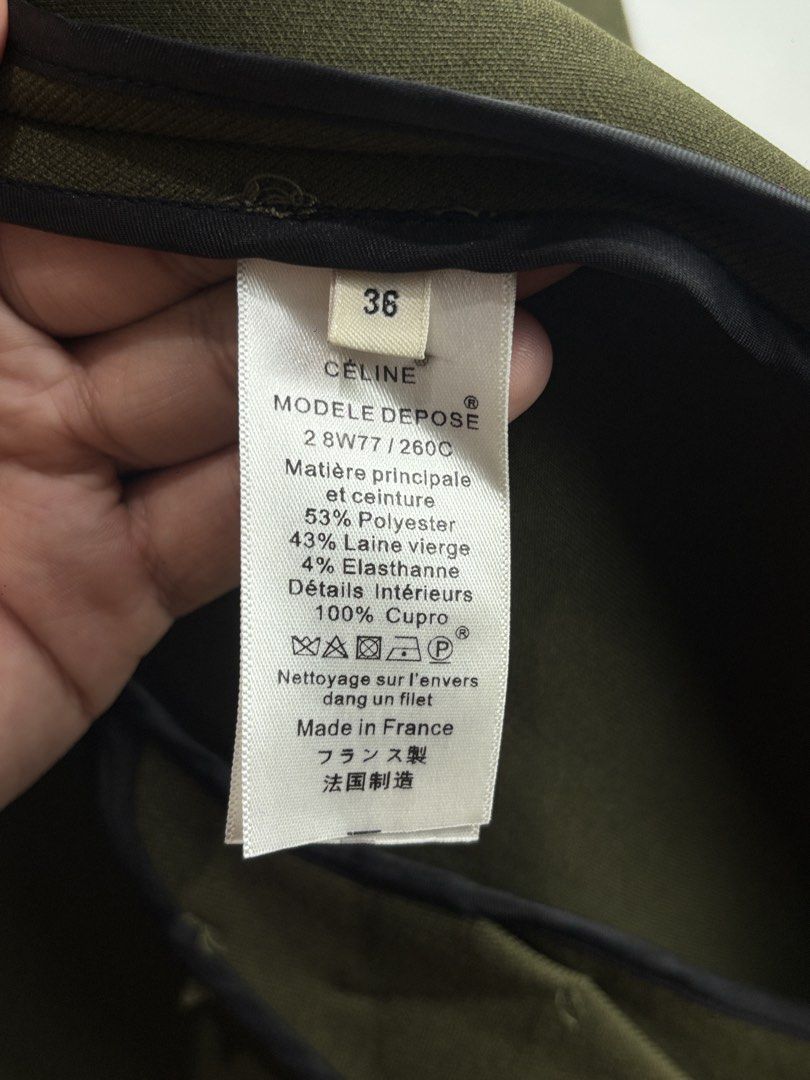 Celine Khaki Green Wool Blend Belted Coat Size 36 (Category: Coats, Jackets and Outerwear) located in Dasmarinas. Submitted by goldengem_e4eb01 (Listing ID 1468971390, Image 3). Description: CE’LINE.RARE AUTHENTIC AW 2018 COLLECTION.WOOL LONG BELTED COAT.DESIGN BY PHOEBE PHILO.STRUCTURED TRENCH COAT WITH WIDE CURVED LAPELS WITH RAISED PIPING DETAILS.A MATCHING WAIST-TIE BELT AND DISTINCTIVE DOME -SHAPED SILVER BUTTONS.A MINIMALIST UTILITY AESTHET