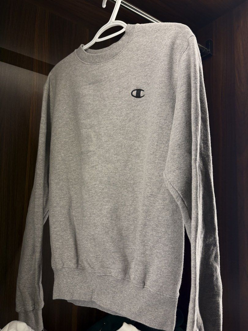 Champion Grey Crewneck Sweatshirt (Category: Coats, Jackets and Outerwear) located in Angeles City. Submitted by curt_morales (Listing ID 1468957667, Image 1). Description: - Brand: Champion - Style: Classic crewneck sweater - Color: Heather grey with black embroidered logo on chest - Material: Soft and warm fleece - Details: Ribbed cuffs, collar, and hem for a snug fit - Condition: Great staple piece, perfect for casual days.