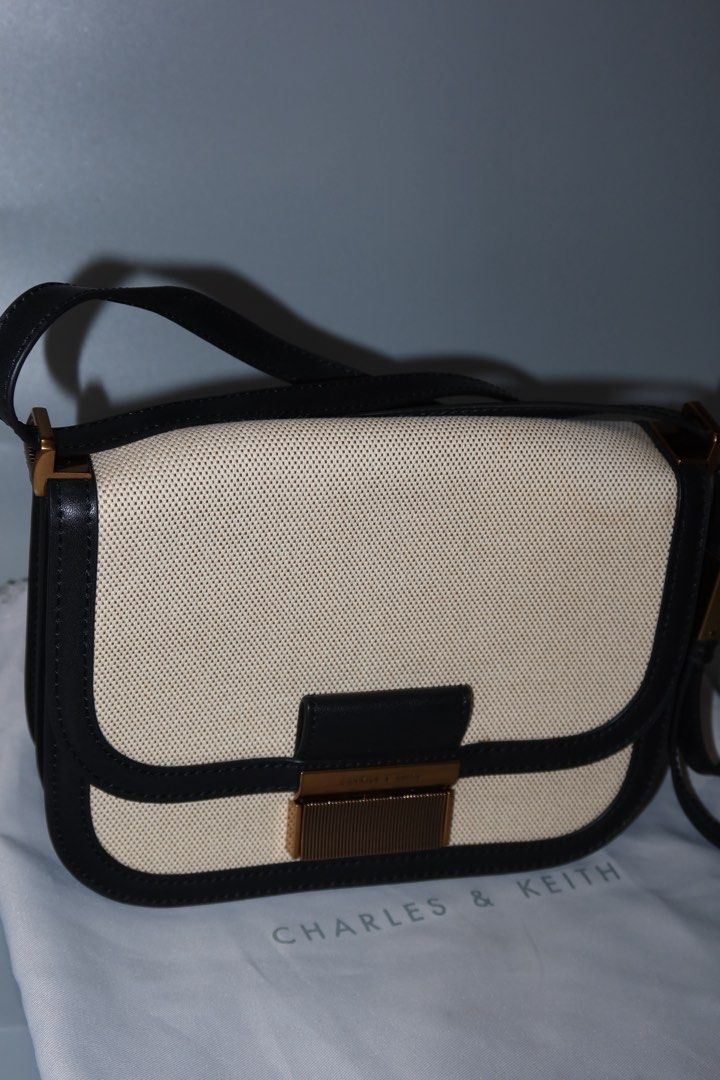 Charles & Keith Black and Beige Shoulder Bag (Category: Shoulder Bags) located in General Trias. Submitted by laiyieeeee (Listing ID 1469011306, Image 1). Description: - Brand: Charles & Keith - Style: Shoulder bag with clean lines and a classic two-tone look - Color/Material: Beige canvas with black trim - Hardware: Elegant gold-tone push-lock closure on front flap - Strap: Adjustable black strap for a comfortable fit - Inclusion: Comes with its
