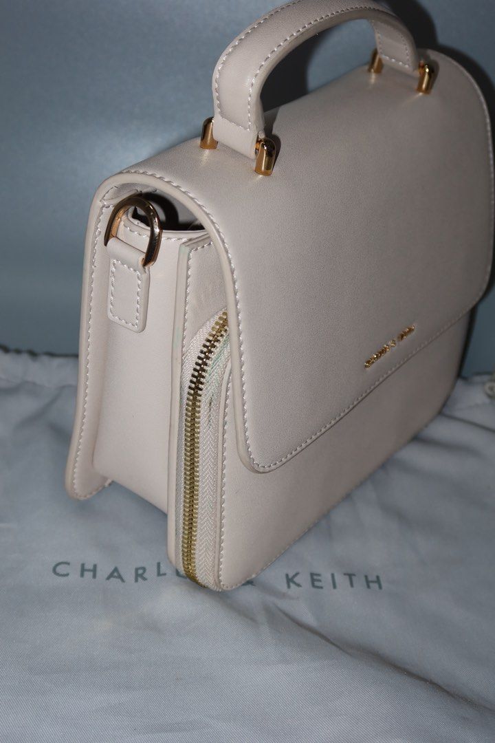 Charles & Keith Cream Top Handle Bag (Category: Shoulder Bags) located in General Trias. Submitted by laiyieeeee (Listing ID 1469011016, Image 2). Description: - Brand: Charles & Keith - Style: Structured top handle bag - Color: Versatile neutral cream - Details: Chic gold-tone hardware and side gusset zip closure - Condition: Clean exterior and interior compartments - Inclusions: Matching branded dust bag - USED ONCE.