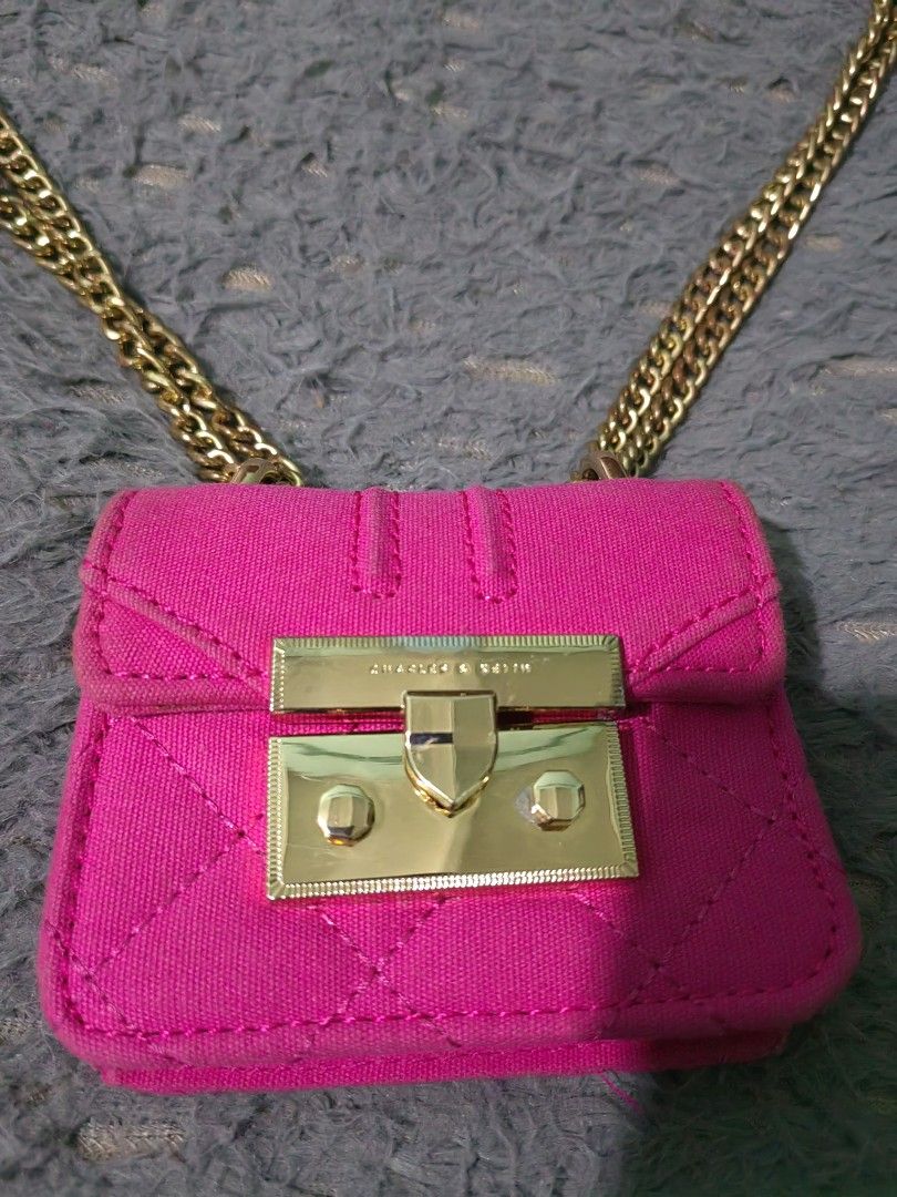 Charles & Keith pink micro bag with gold chain (Category: Luxury Bags & Wallets) located in Las Pinas. Submitted by huslerz (Listing ID 1469059952, Image 3). Description: - Brand: Charles & Keith - Color: Bright pink - Material: Quilted fabric with shiny gold hardware - Closure: Secure push-lock - Strap: Long gold chain for cross-body wear - Capacity: Compact (fits tiny essentials like coins or lipstick) - Details: Clean finish with readable bran