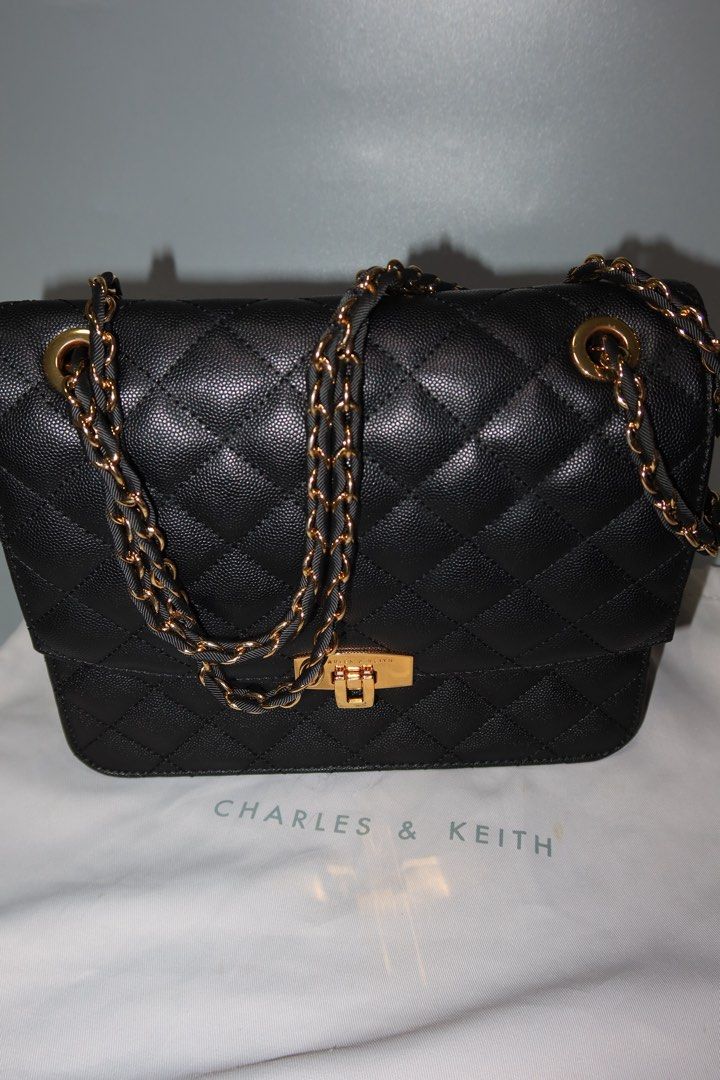Charles & Keith Quilted Black Chain Bag (Category: Luxury Bags & Wallets) located in General Trias. Submitted by laiyieeeee (Listing ID 1469011186, Image 1). Description: - Brand: Charles & Keith - Color: Classic Black - Material: Textured faux leather with diamond pattern stitching - Hardware: Elegant gold-tone details with secure turn-lock closure - Strap: Gold and black interwoven chain strap - Inclusion: Comes with original Charles & Keith du