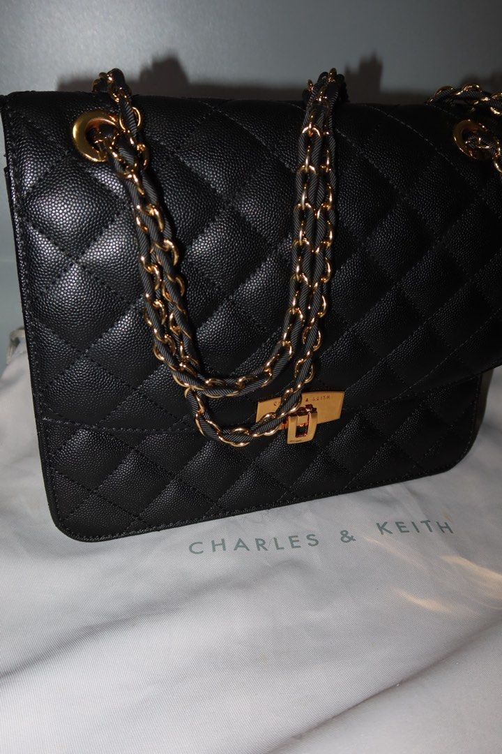 Charles & Keith Quilted Black Chain Bag (Category: Luxury Bags & Wallets) located in General Trias. Submitted by laiyieeeee (Listing ID 1469011186, Image 2). Description: - Brand: Charles & Keith - Color: Classic Black - Material: Textured faux leather with diamond pattern stitching - Hardware: Elegant gold-tone details with secure turn-lock closure - Strap: Gold and black interwoven chain strap - Inclusion: Comes with original Charles & Keith du