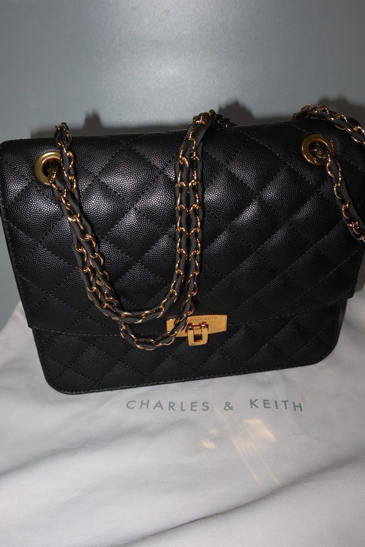 Charles & Keith Quilted Black Chain Bag (Category: Luxury Bags & Wallets) located in General Trias. Submitted by laiyieeeee (Listing ID 1469011186, Image 3). Description: - Brand: Charles & Keith - Color: Classic Black - Material: Textured faux leather with diamond pattern stitching - Hardware: Elegant gold-tone details with secure turn-lock closure - Strap: Gold and black interwoven chain strap - Inclusion: Comes with original Charles & Keith du