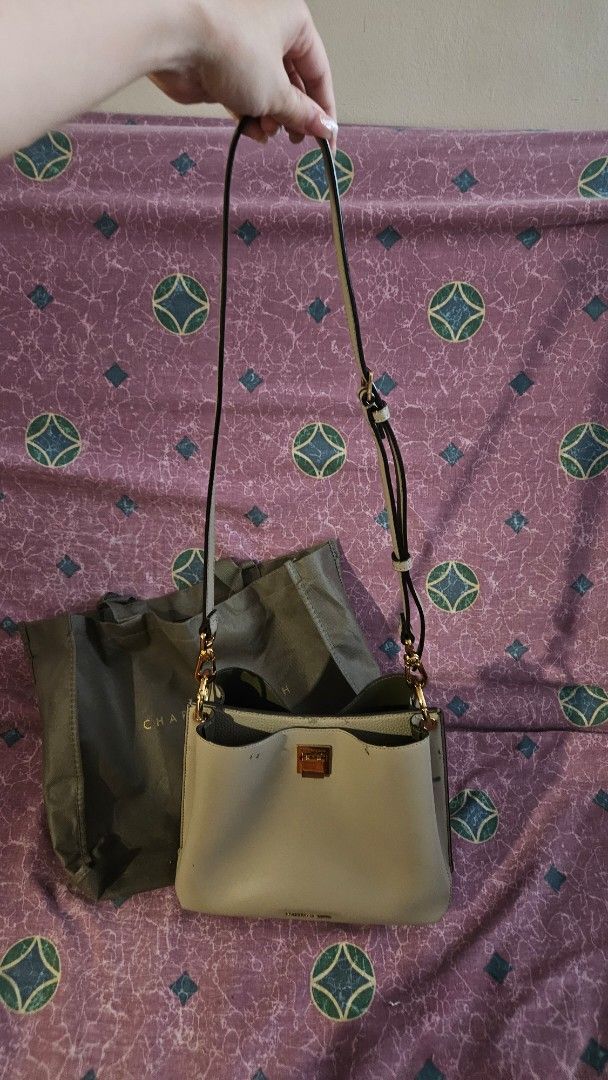 Charles & Keith Taupe Sling Bag (Category: Shoulder Bags) located in Pasig City. Submitted by samjavxx (Listing ID 1469093788, Image 2). Description: Bought in 2019 only used once. Minor signs of leather aging as seen in pictures Buyer to shoulder delivery via grab/lalamove, pick up point in Ortigas area Pasig - Brand: Charles & Keith - Style: Structured shoulder bag in muted green with gold-tone hardware - Closure: Secure lock closure on front f