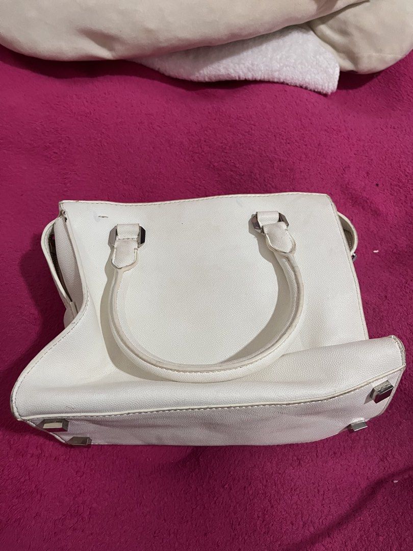 Charles & Keith White Structured Handbag (Category: Luxury Bags & Wallets) located in Manila. Submitted by waveyvabes (Listing ID 1469076018, Image 3). Description: - Brand: Charles & Keith - Color: Classic White with sleek silver-tone hardware - Material: Premium textured faux leather - Features: Structured design, protective metal feet at the bottom - Straps: Dual top handles + detachable shoulder strap for versatile wear - Compartments: Secure