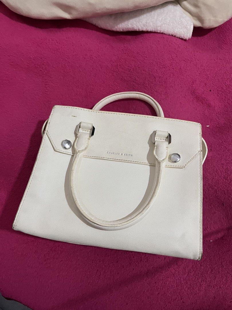 Charles & Keith White Structured Handbag (Category: Luxury Bags & Wallets) located in Manila. Submitted by waveyvabes (Listing ID 1469076018, Image 1). Description: - Brand: Charles & Keith - Color: Classic White with sleek silver-tone hardware - Material: Premium textured faux leather - Features: Structured design, protective metal feet at the bottom - Straps: Dual top handles + detachable shoulder strap for versatile wear - Compartments: Secure