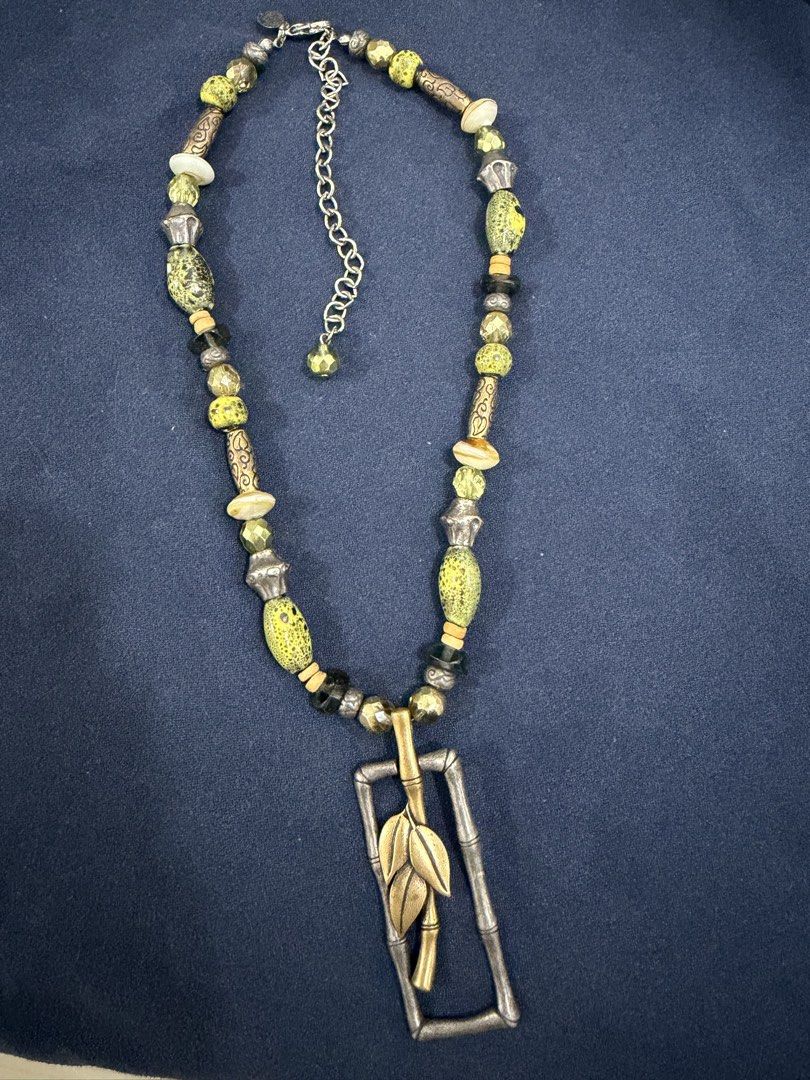 Chico's Statement Necklace with Bamboo and Leaf Pendant (Category: Necklaces) located in Makati City. Submitted by petite_preloved2 (Listing ID 1469064196, Image 1). Description: - Brand: Chico's - Design: Earthy green, yellow, and metallic beads with a large rectangular pendant - Details: Silver-toned bamboo frame with gold-toned leaves and clear maker stamp on the back - Closure: Adjustable chain with secure lobster clasp - Condition: Good pre-