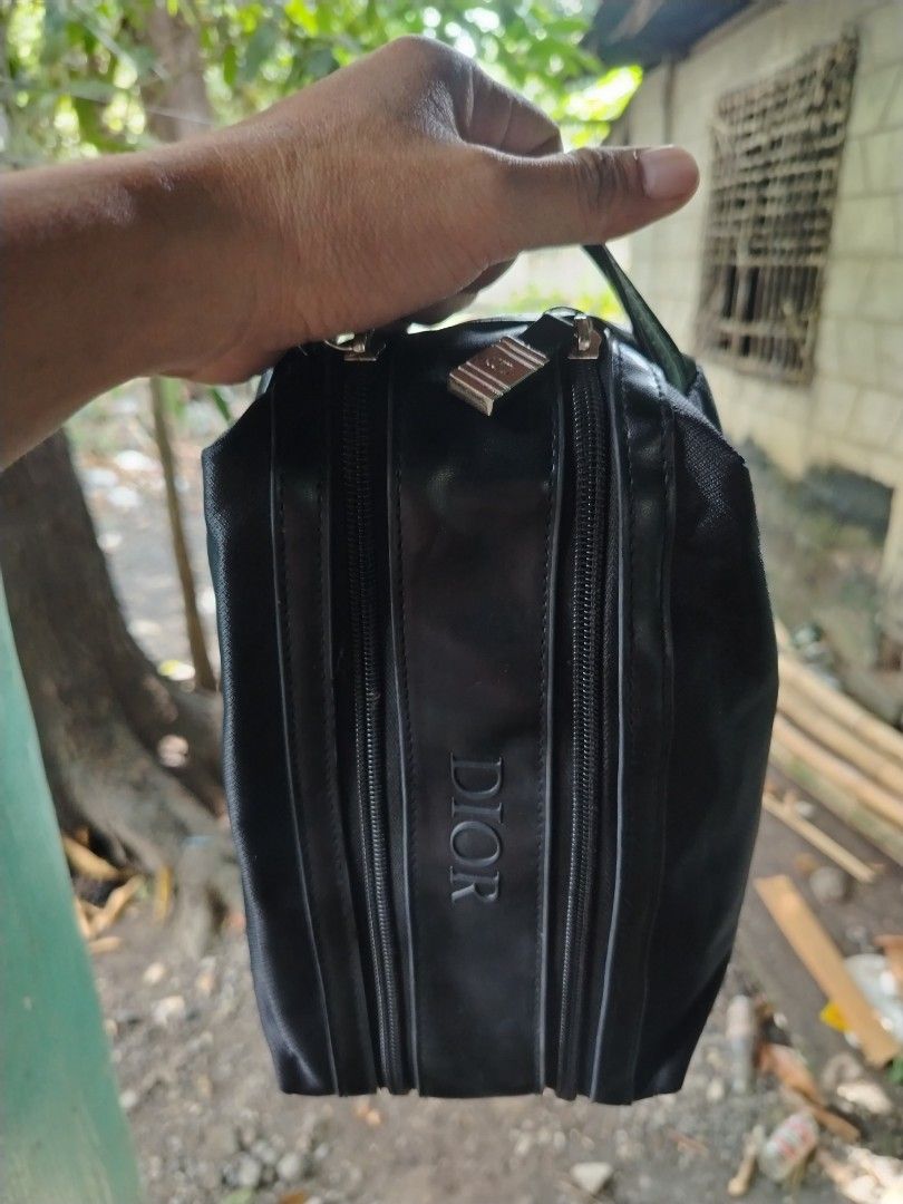 Christian Dior Black Toiletry Bag (Category: Luxury Bags & Wallets) located in Caloocan City. Submitted by vincefresn21903 (Listing ID 1468955715, Image 3). Description: Black Christian Dior pouch with dual zippered compartments. Sturdy nylon and faux leather material. Compact size for daily essentials or travel gear. Debossed Dior logo on the front panel. Wrist strap attached on the side. Silver tone hardware zippers work smoothly..