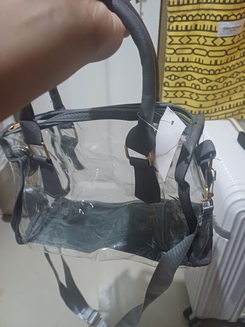 Clear transparent handbag with grey trim and shoulder strap (Category: Cross-body Bags) located in Imus. Submitted by bagginholicetc. (Listing ID 1469002043, Image 3). Description: Flaws- sira yung zipper paayos nyo na lang. - Color/Detail: Clear bag with chic grey trim and gold-tone hardware - Closure: Top zipper closure to keep your belongings secure - Versatile Carry: Includes dual top handles and a detachable long shoulder strap - Perfect For